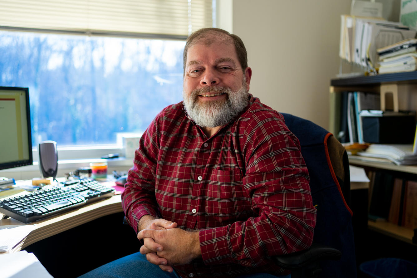 Jon Dillow smiles for a photo in his office.