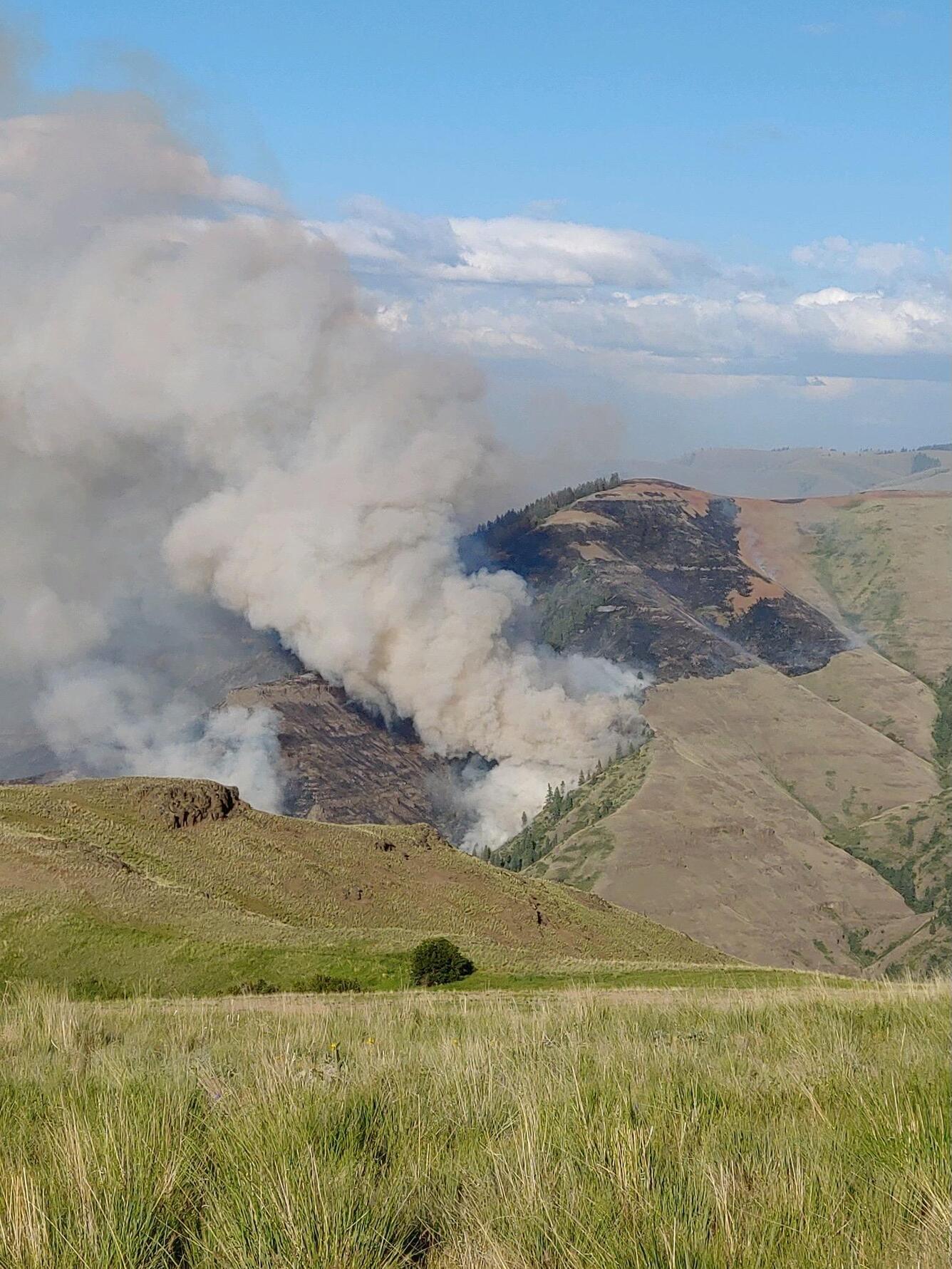 Photo of a mountain with smoke billowing up