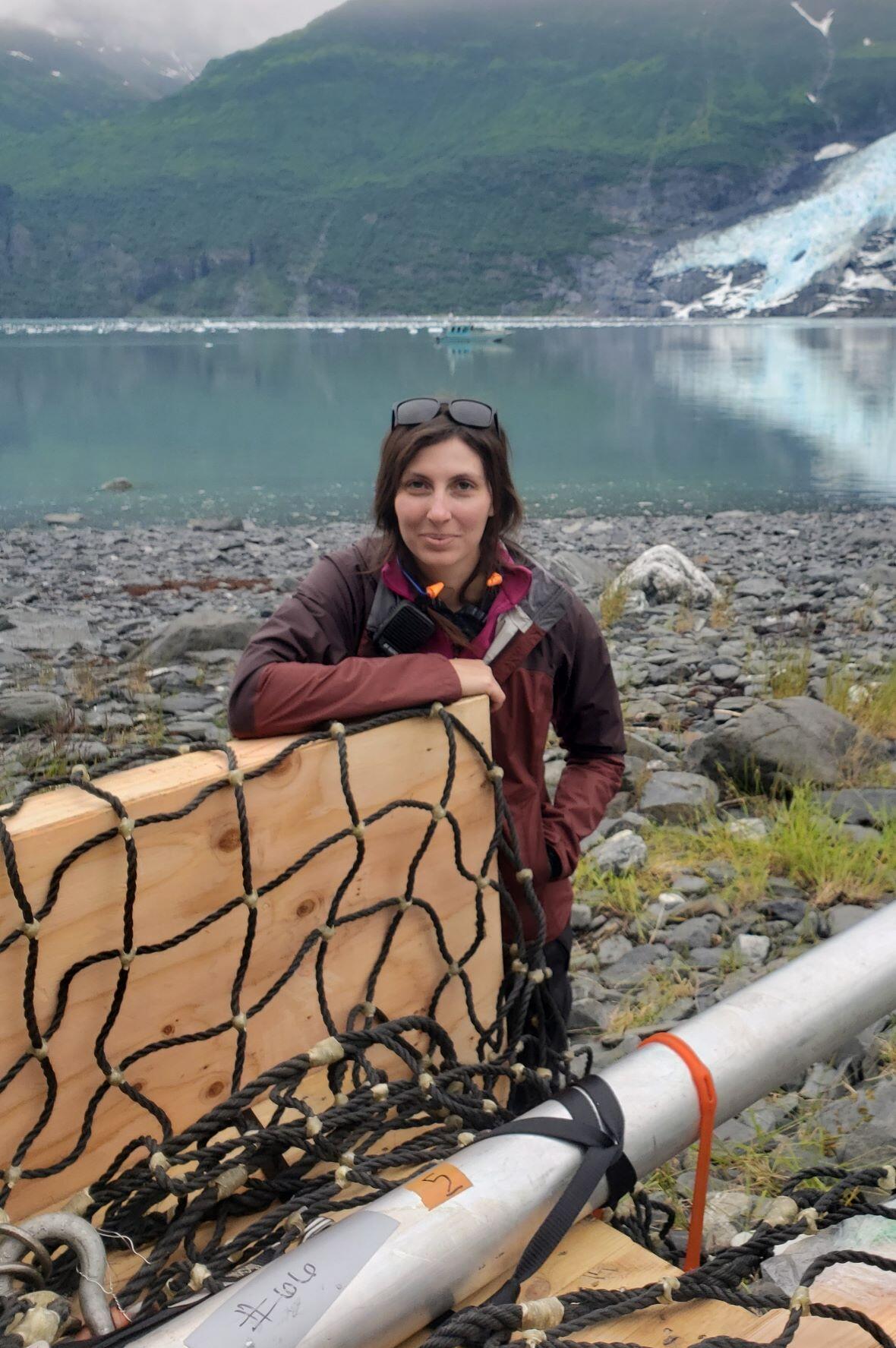 person standing next to water, rocks, and ice