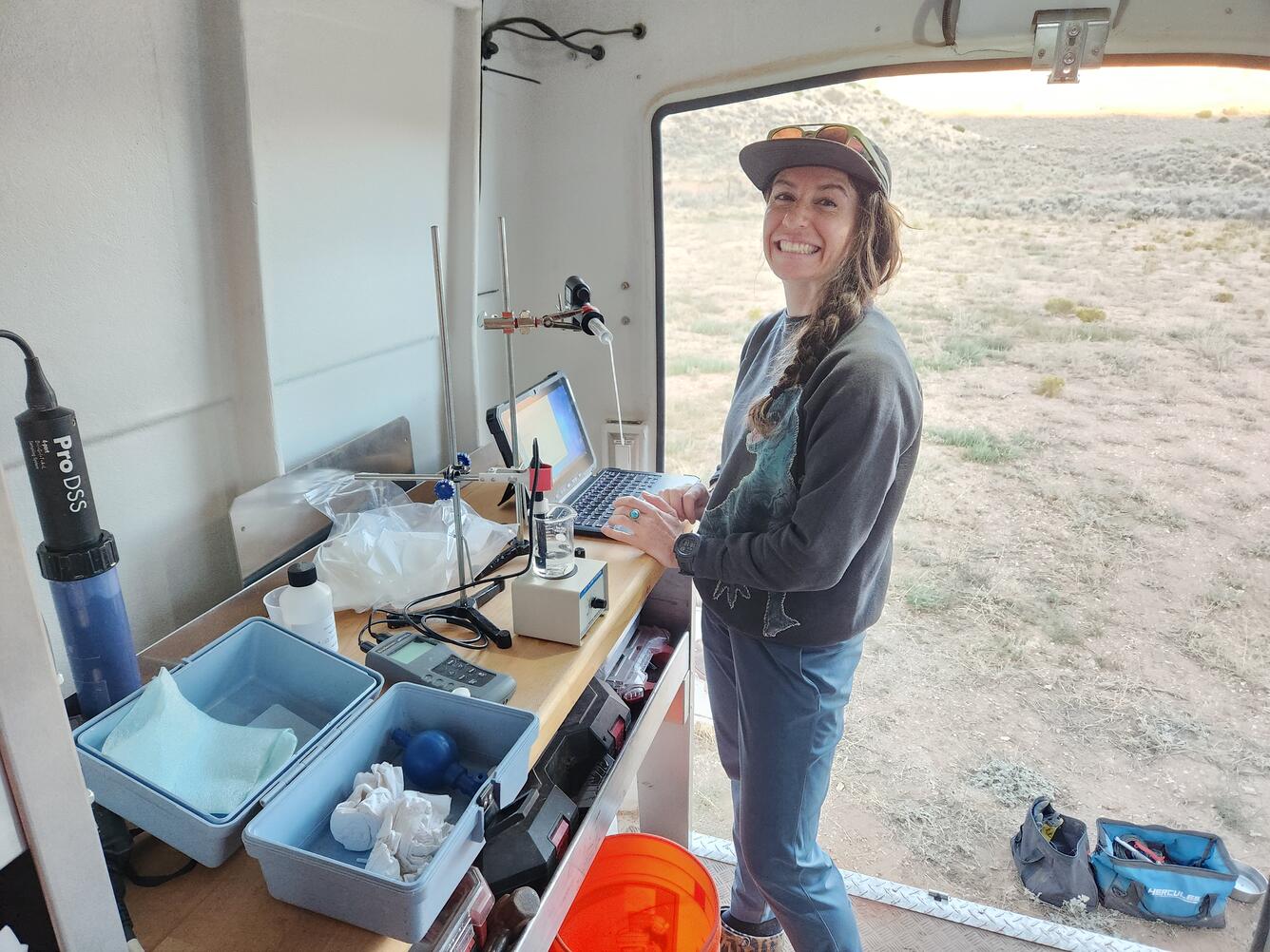 Kat Cooney smiles as she runs an alkalinity titration in a mobile lab