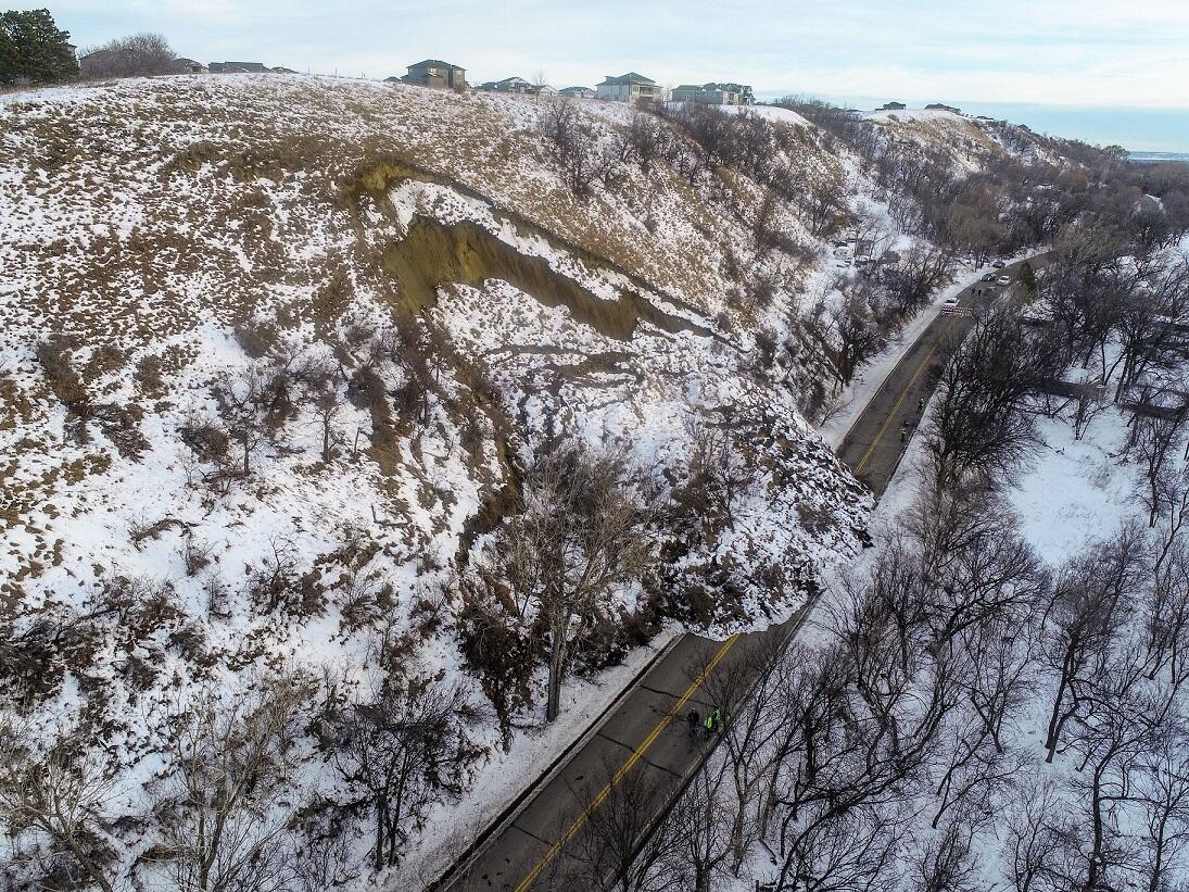 snow on hillslope that is sliding onto road