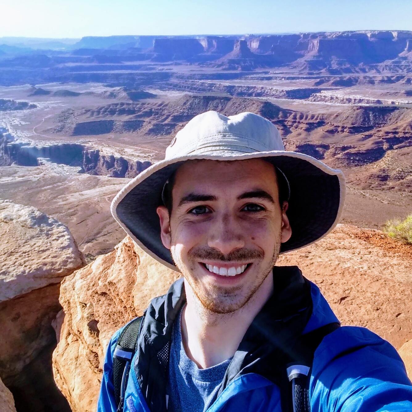 man standing in front of a large canyon