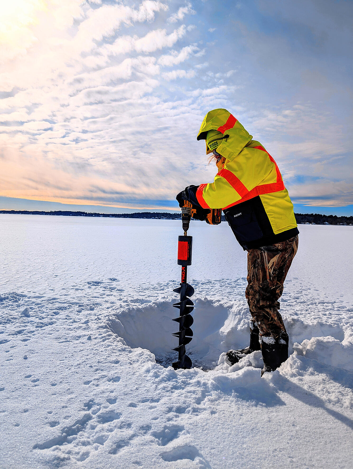 Technician bores a hole in a frozen lake to take water quality samples on Long Pond, Lakeville, MA.