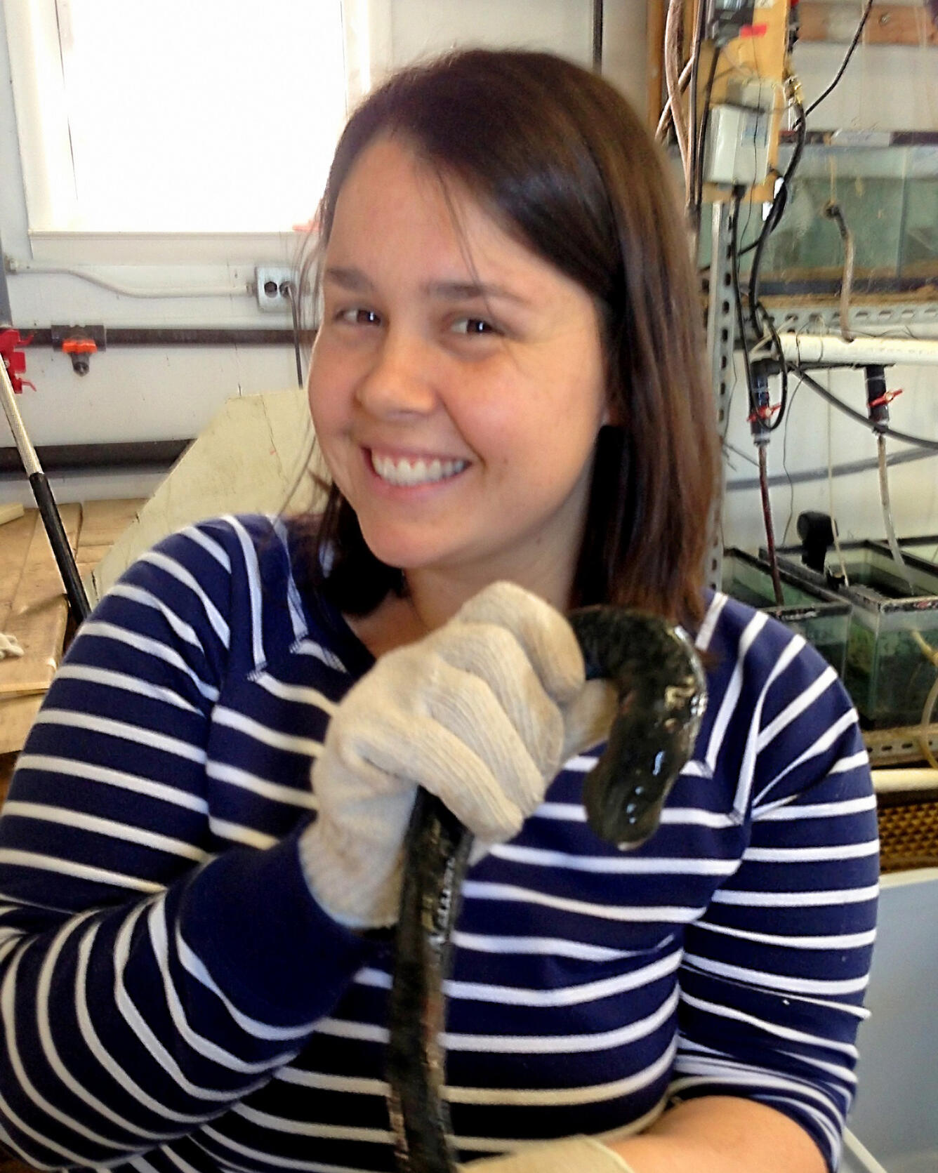 Lauren Holbrook holding a sea lamprey in a lab