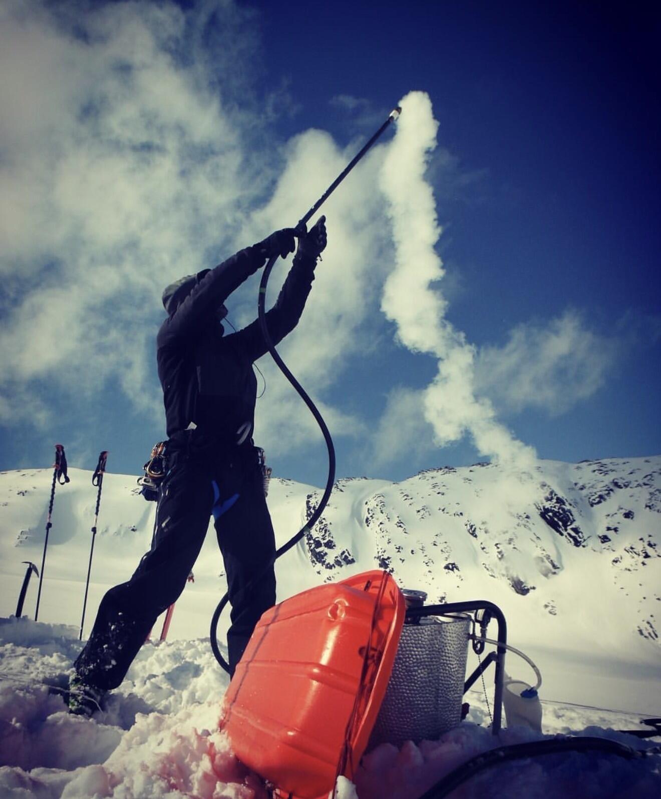 Person holding a pipe with steam coming out of one end.