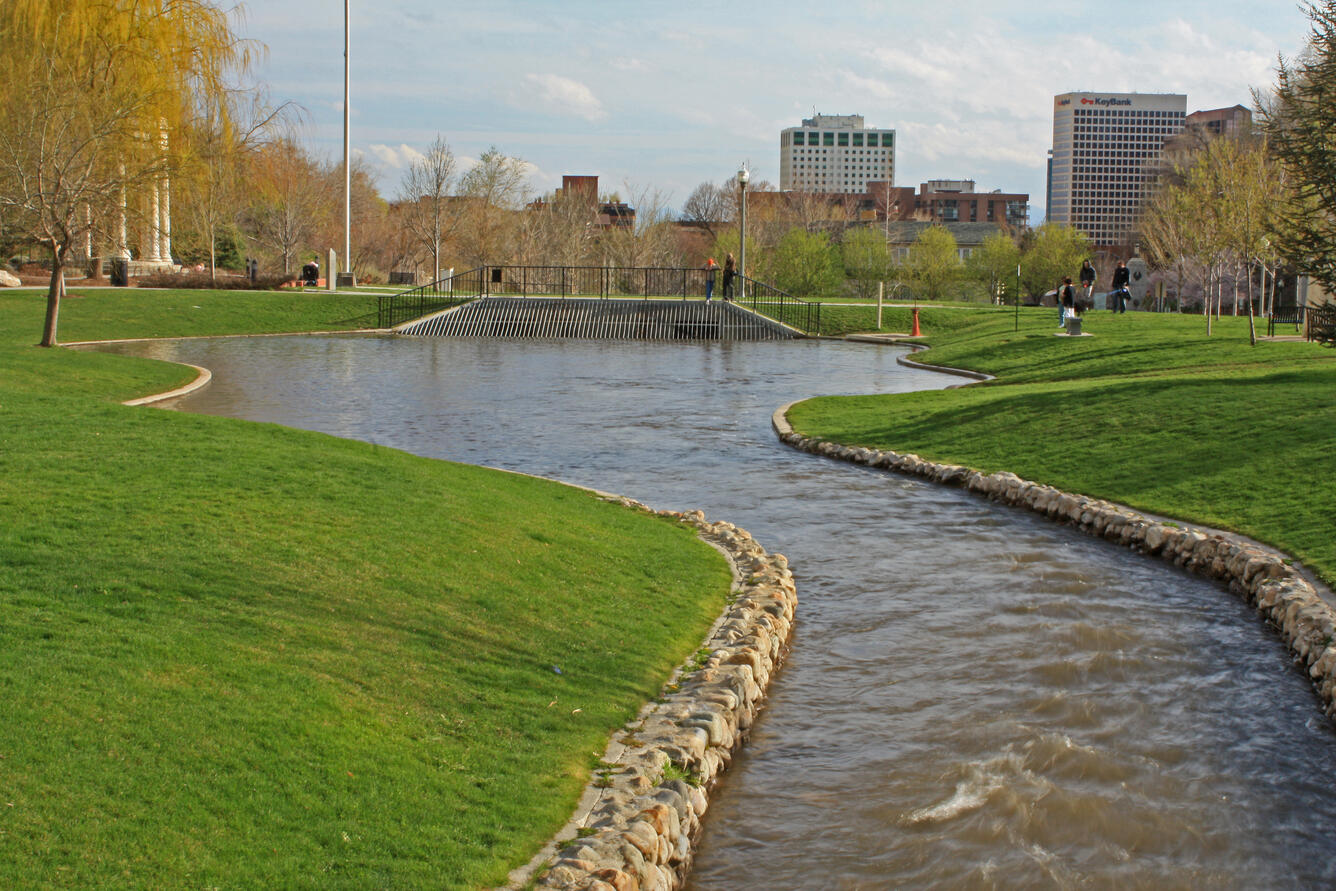 stream in front of large urban buildings surrounded by lawn