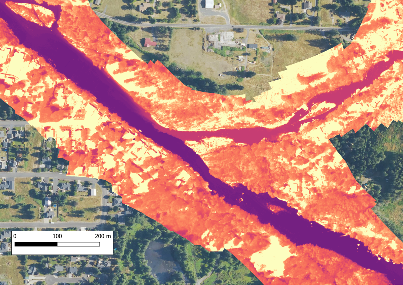 aerial view of two rivers color coded with thermal data join in a lightly populated woodland area. See caption. 