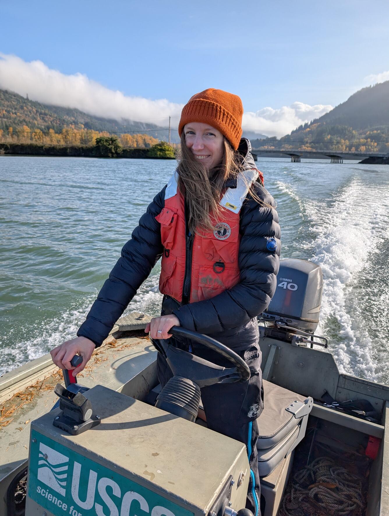 woman driving USGS boat in orange beanie
