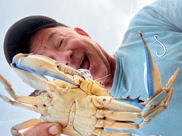 Man holding a crab up to the camera