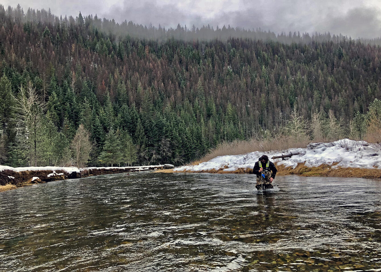 U.S. Geological Survey hydrologic technician Mike Michelotti collects water samples from the South Fork Coeur d'Alene River near Pinehurst, Idaho.