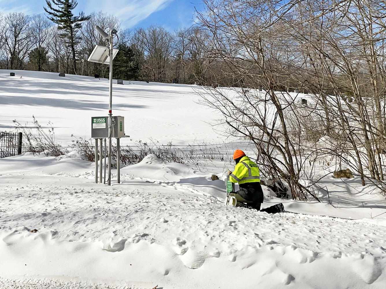 Photograph of a well in the snow. A USGS hydrologic technician making a groundwater measurement in Montgomery, Massachusetts (USGS station 421240072490201).