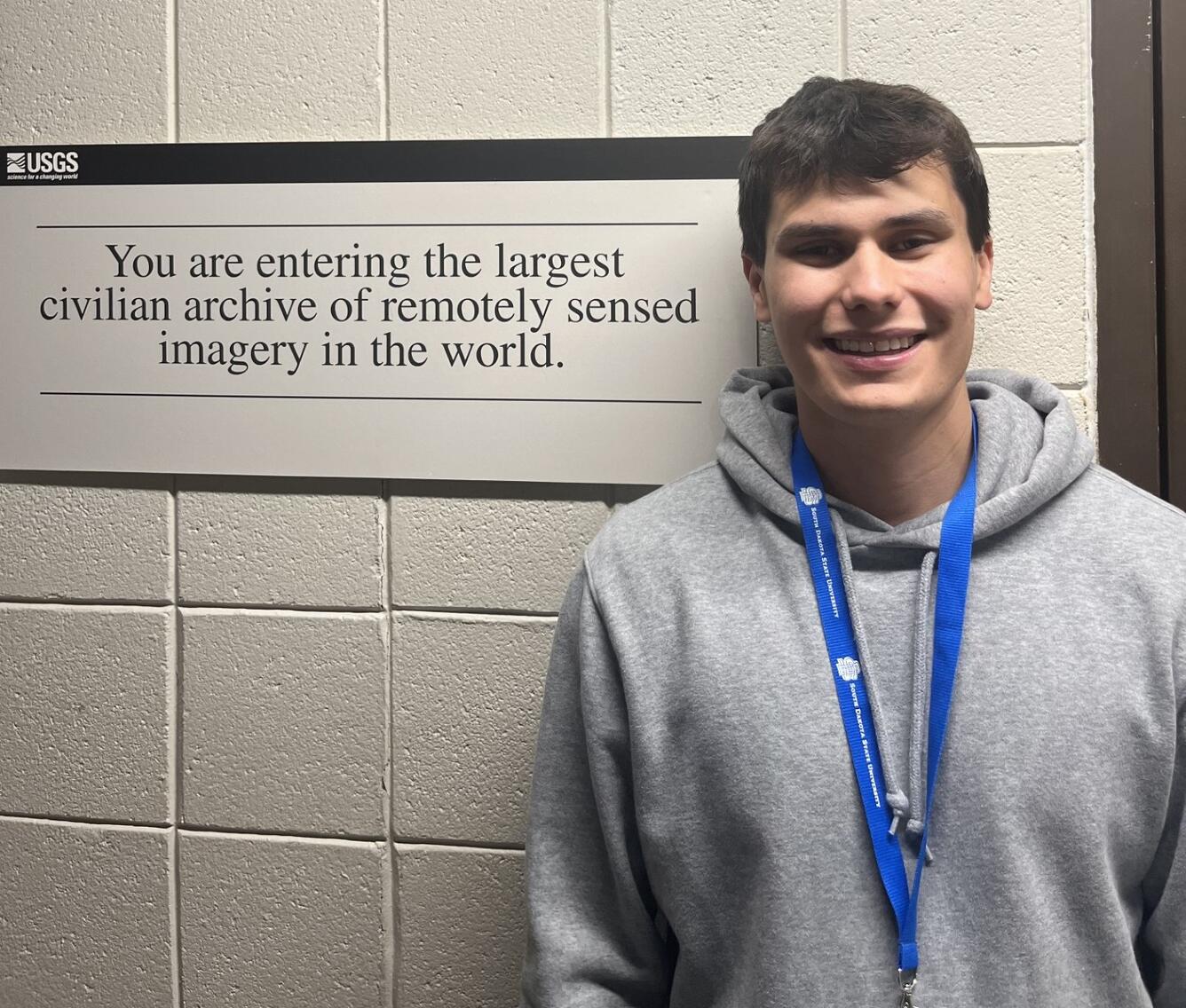 A man standing next to a sign
