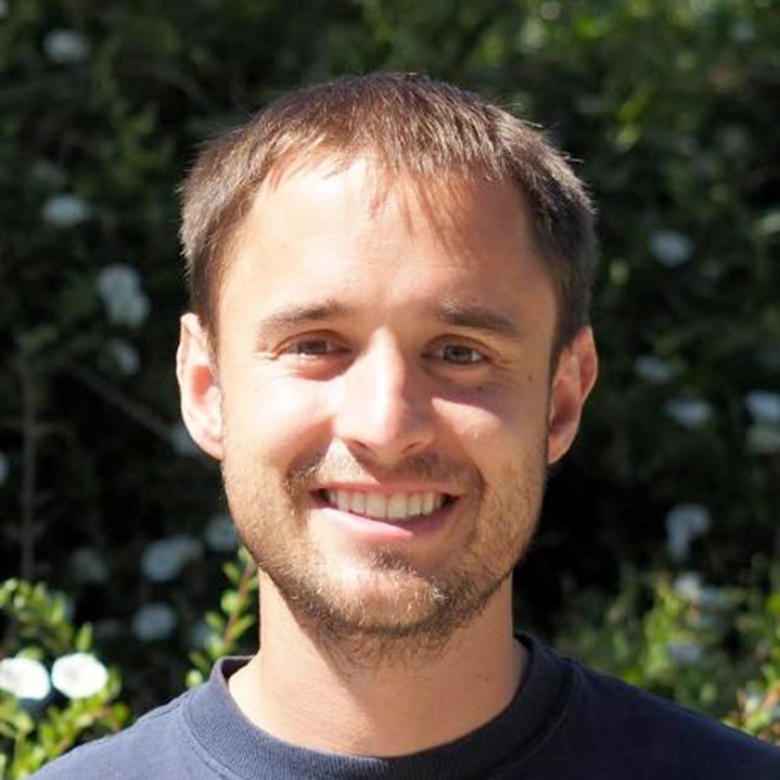 Man with short brown hair smiling widely