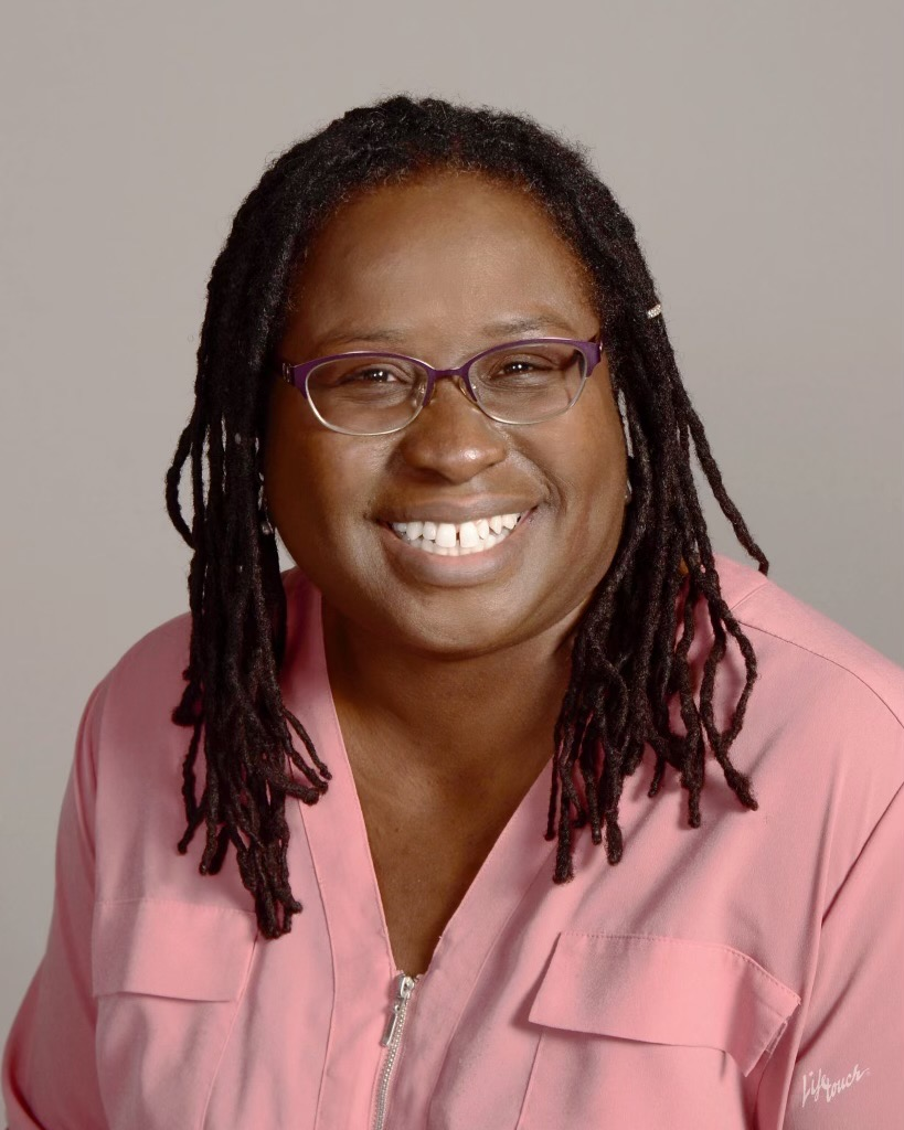Profile image of a woman in glasses and a pink shirt