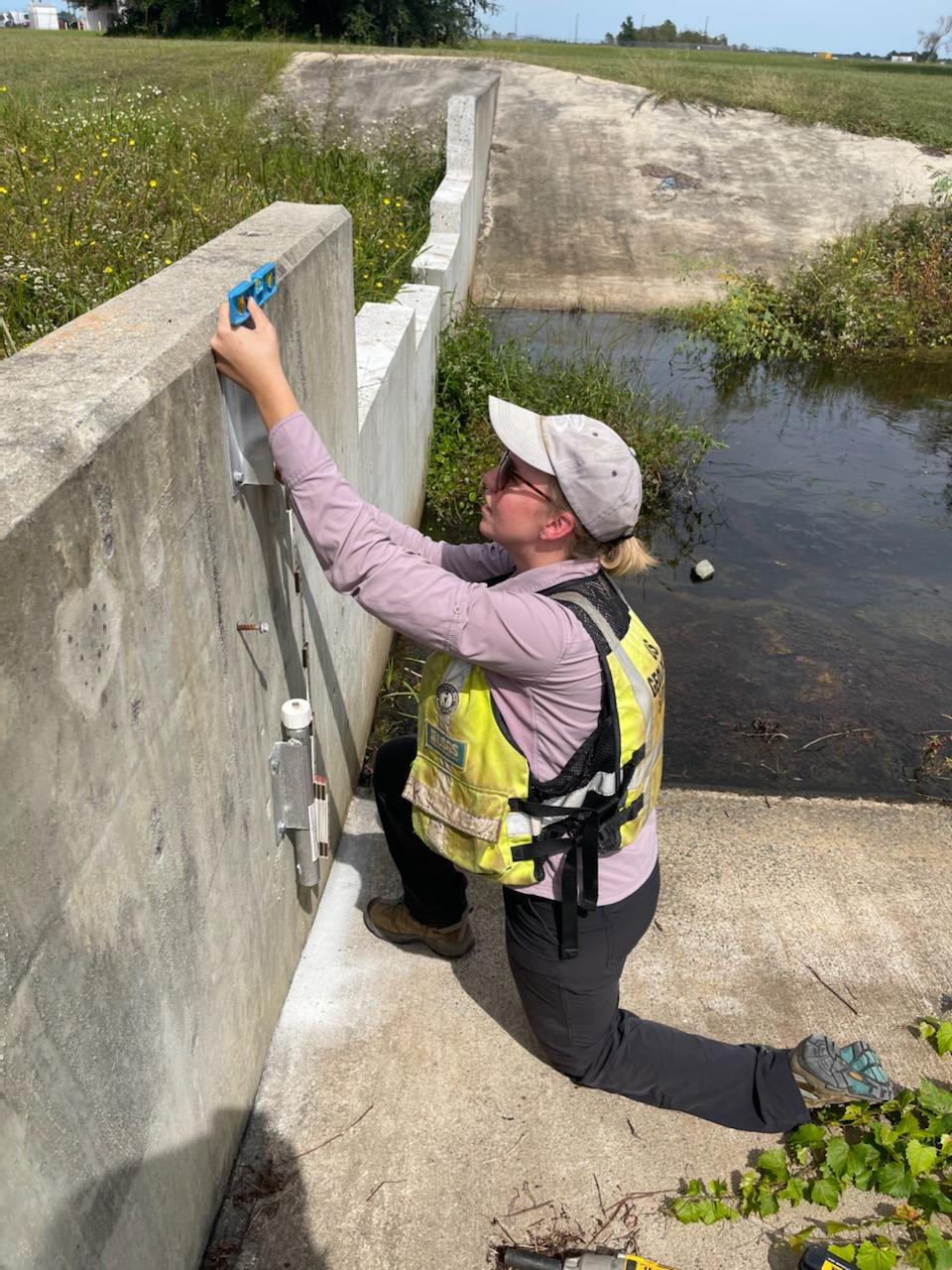 Shelby Daniel, a USGS hydrologic technician, installs a storm-tide sensor in Brunswick, Georgia September 27 in preparation for Hurricane Ian’s arrival.