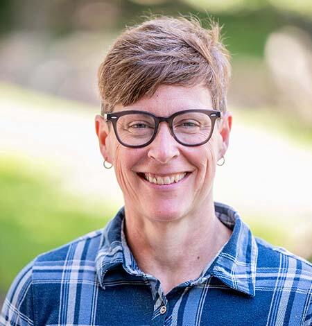 Mikki Johnson with short brown hair glasses and a big smile