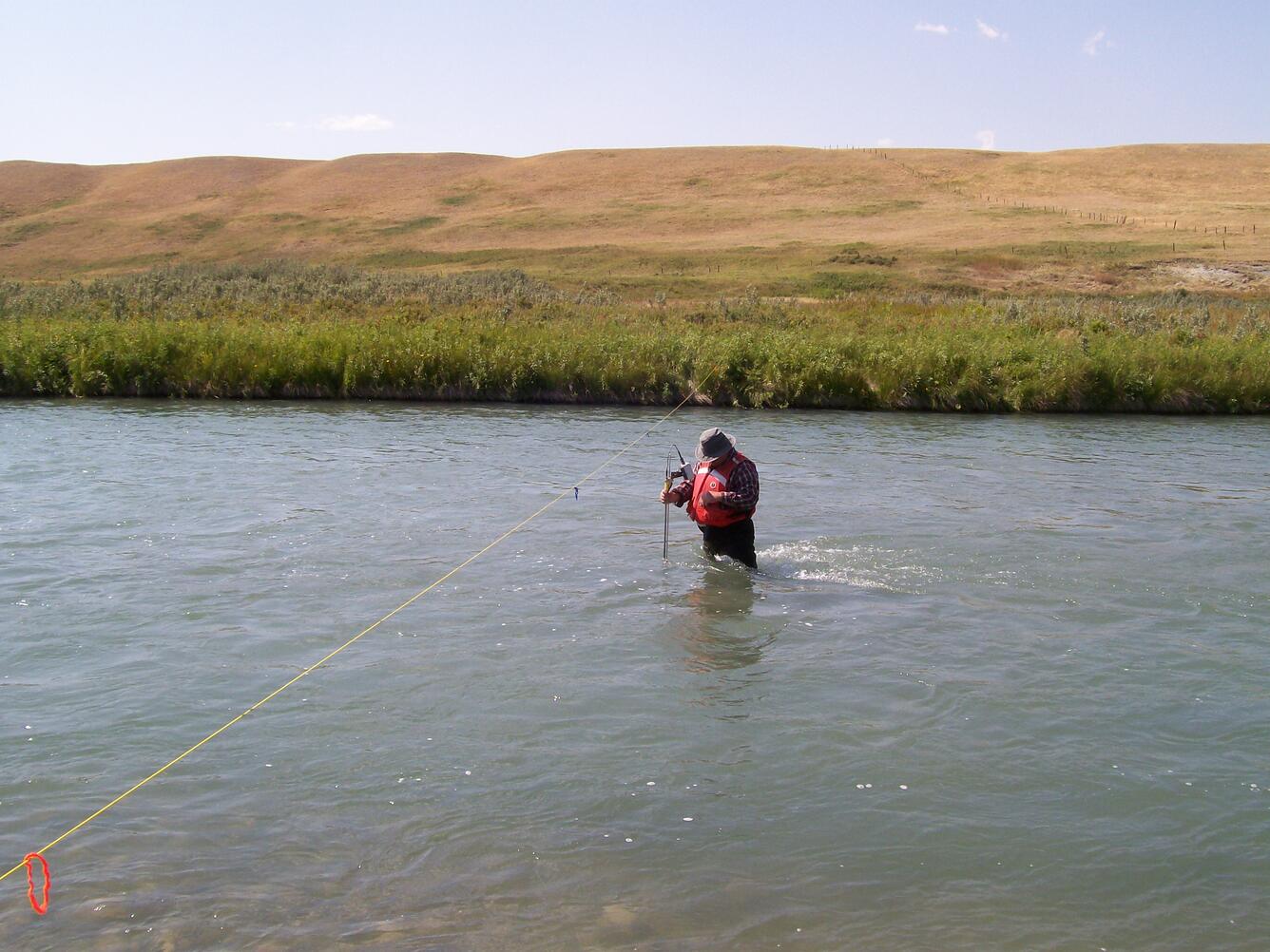 A researcher stands in the Milk River