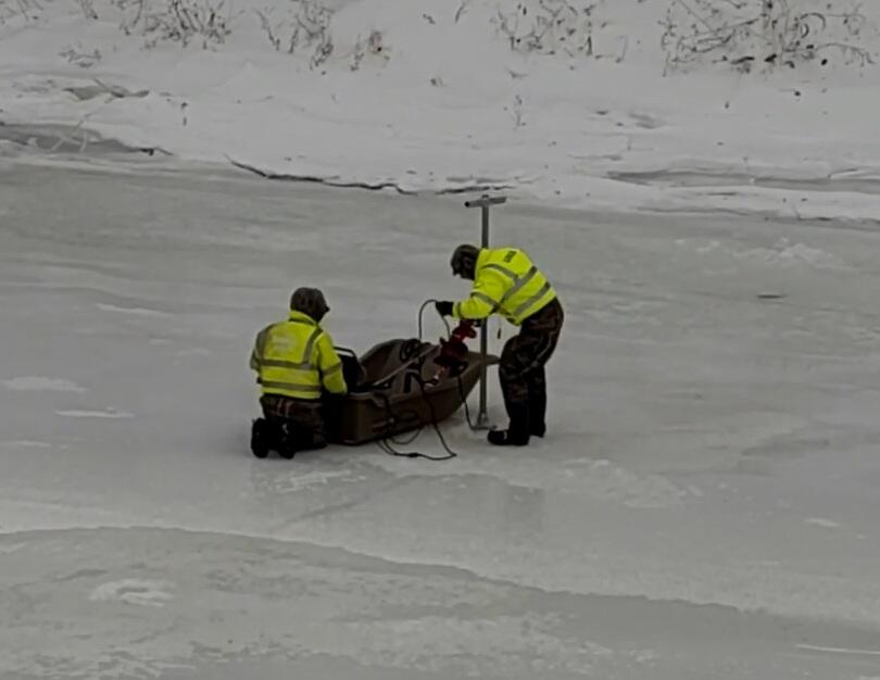 Two Scientists working off of a sled on a frozen river 