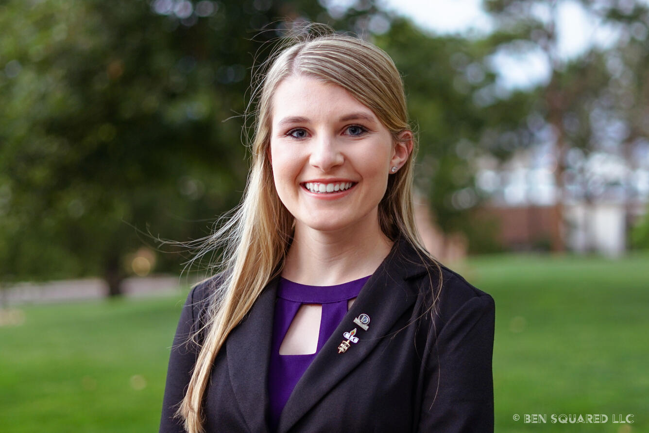 Portrait image of USGS employee Morgan Schachterle, with a blurred green landscape in the background