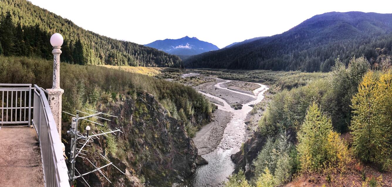 antennas mounted on a concrete balcony high above a gravelly braided river running through steep forested hills