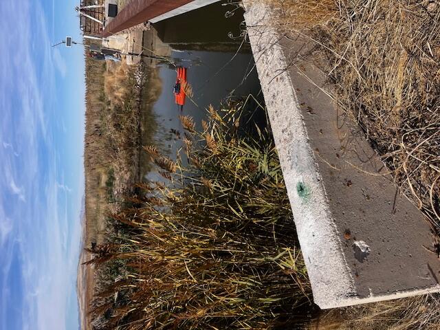 View across river next to low bridge with gage on opposite side.