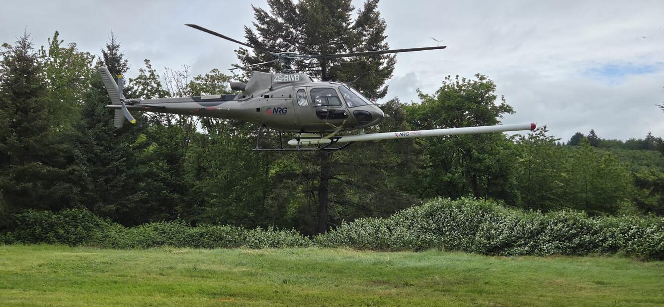 helicopter with front-mounted stinger containing equipment for conducting airborne geophysical surveys.