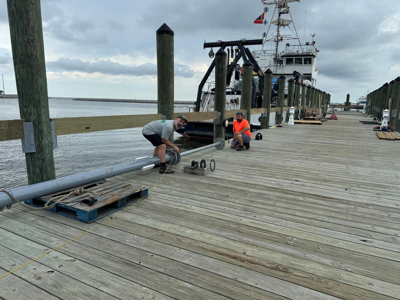 Two people on dock working with coring equipment