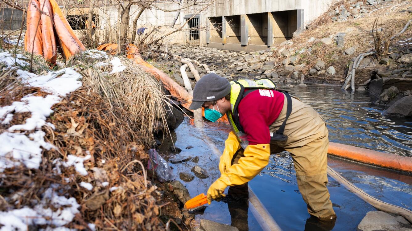A scientist samples at a streambank.
