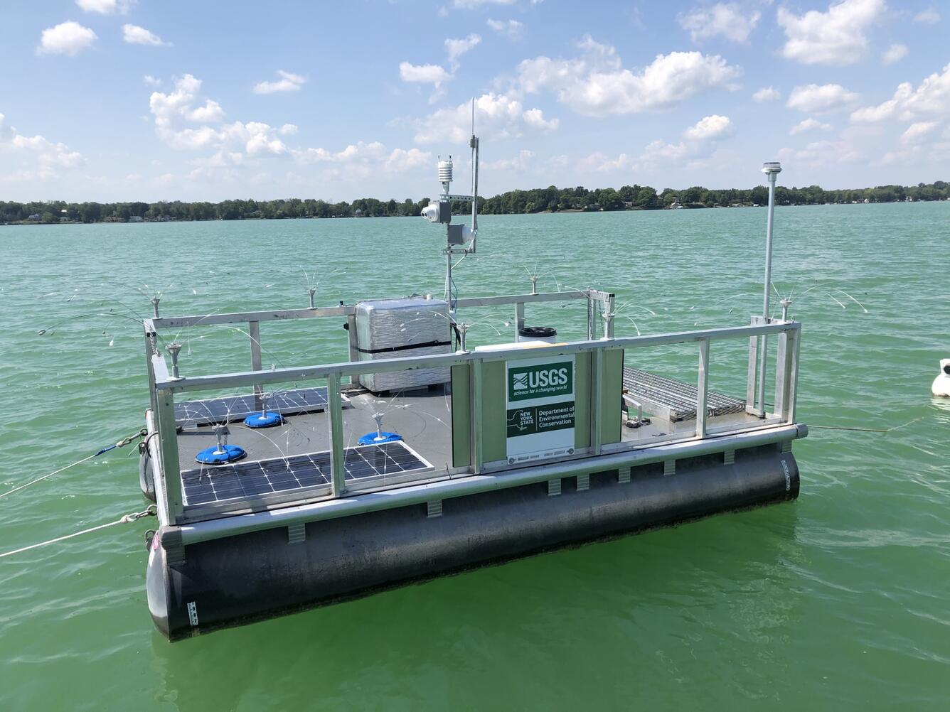 A rectangular platform floats on green tinted waters