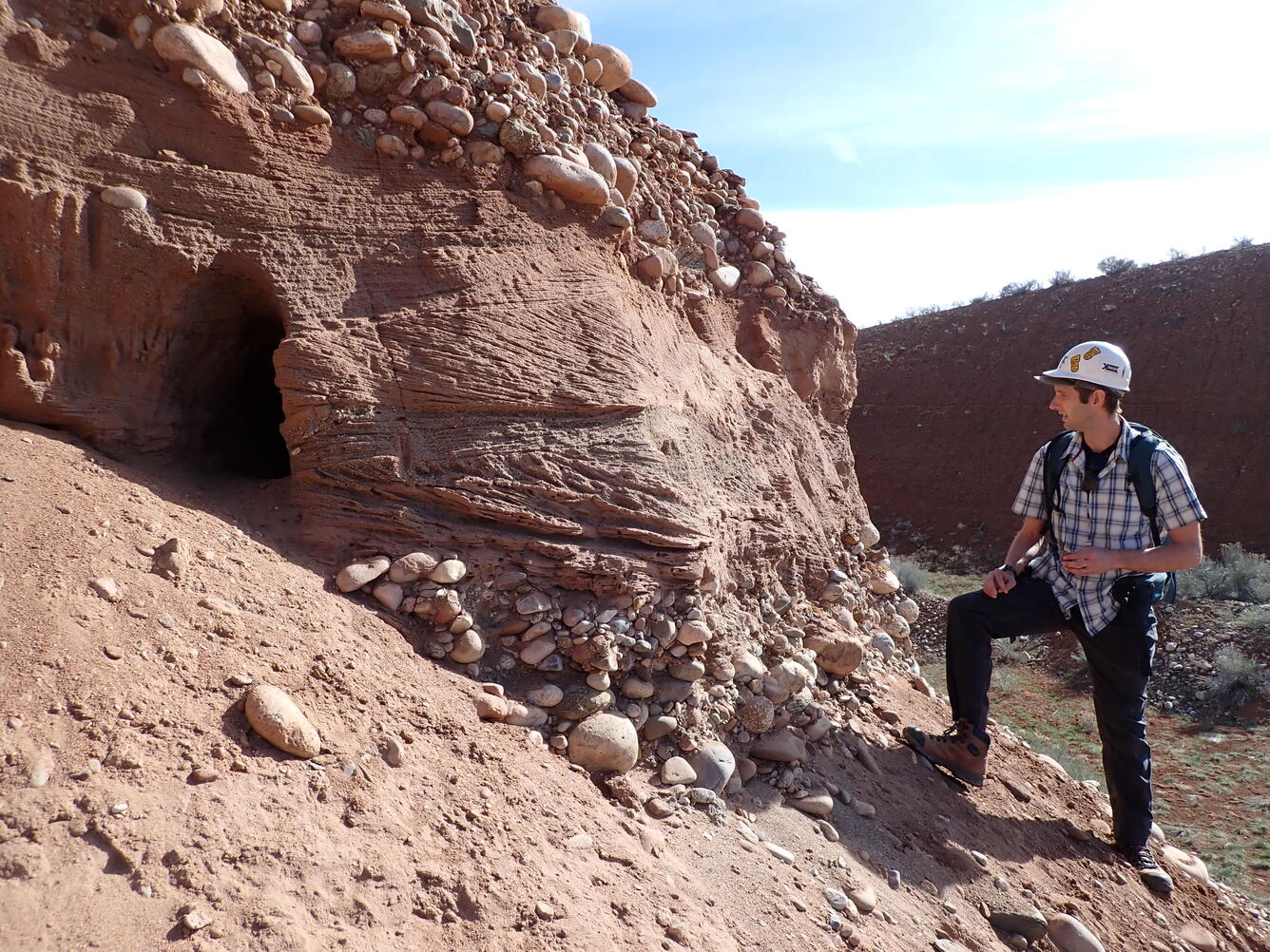 USGS Research Geologist standing in front of terrace deposit