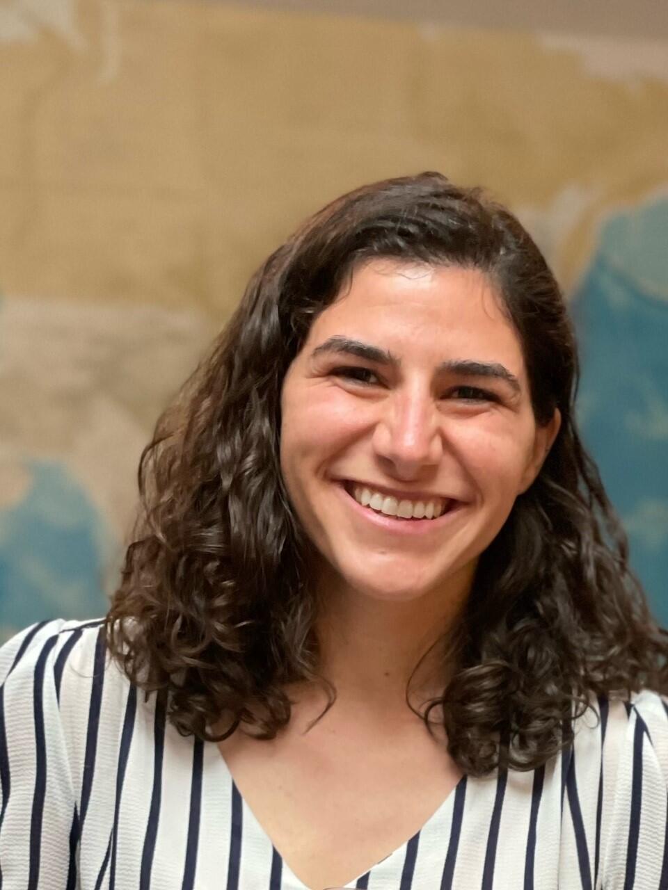 A woman stands in front of a map