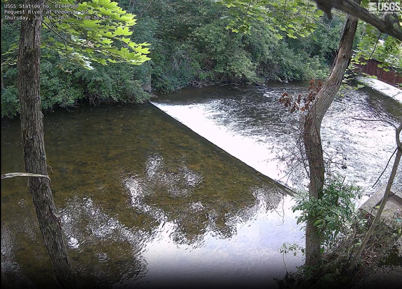 Looking downstream from a high vantage point as the river flows over a weir creating turbulence downstream