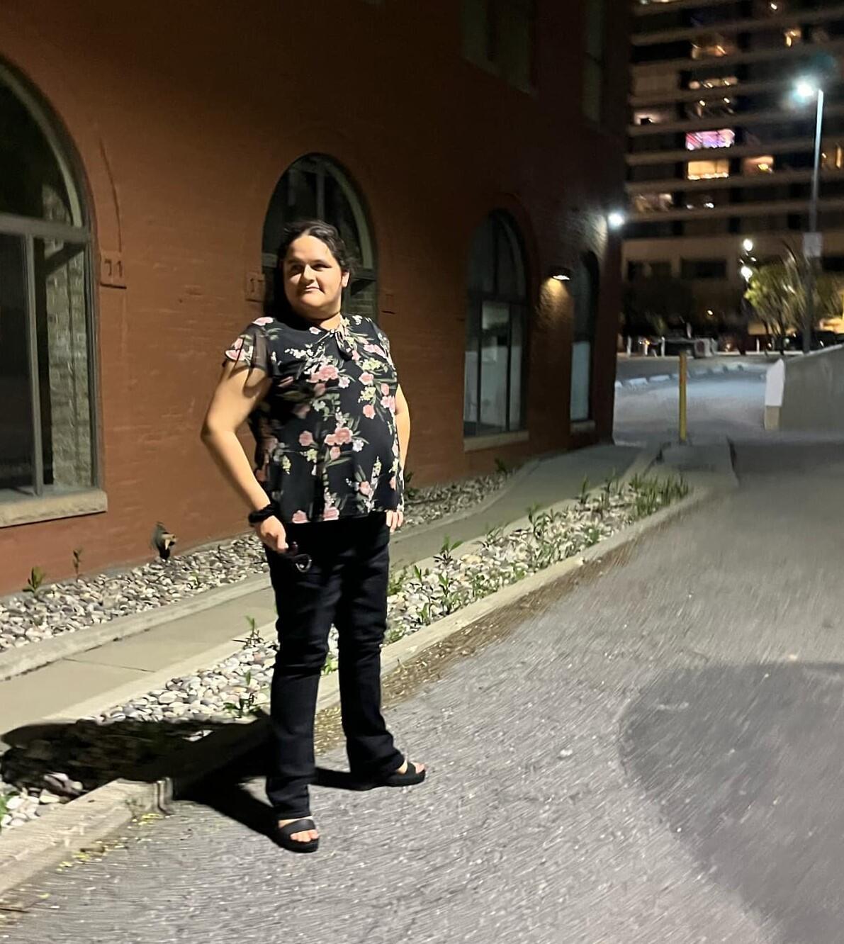 Women in front of building at night.