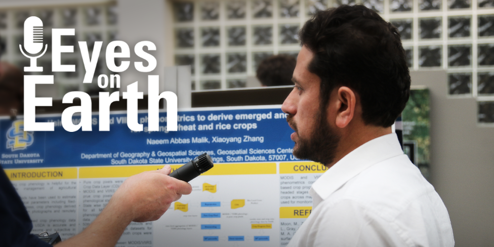A man's profile in front of a science poster with a microphone being held in front of him and a logo placed on top