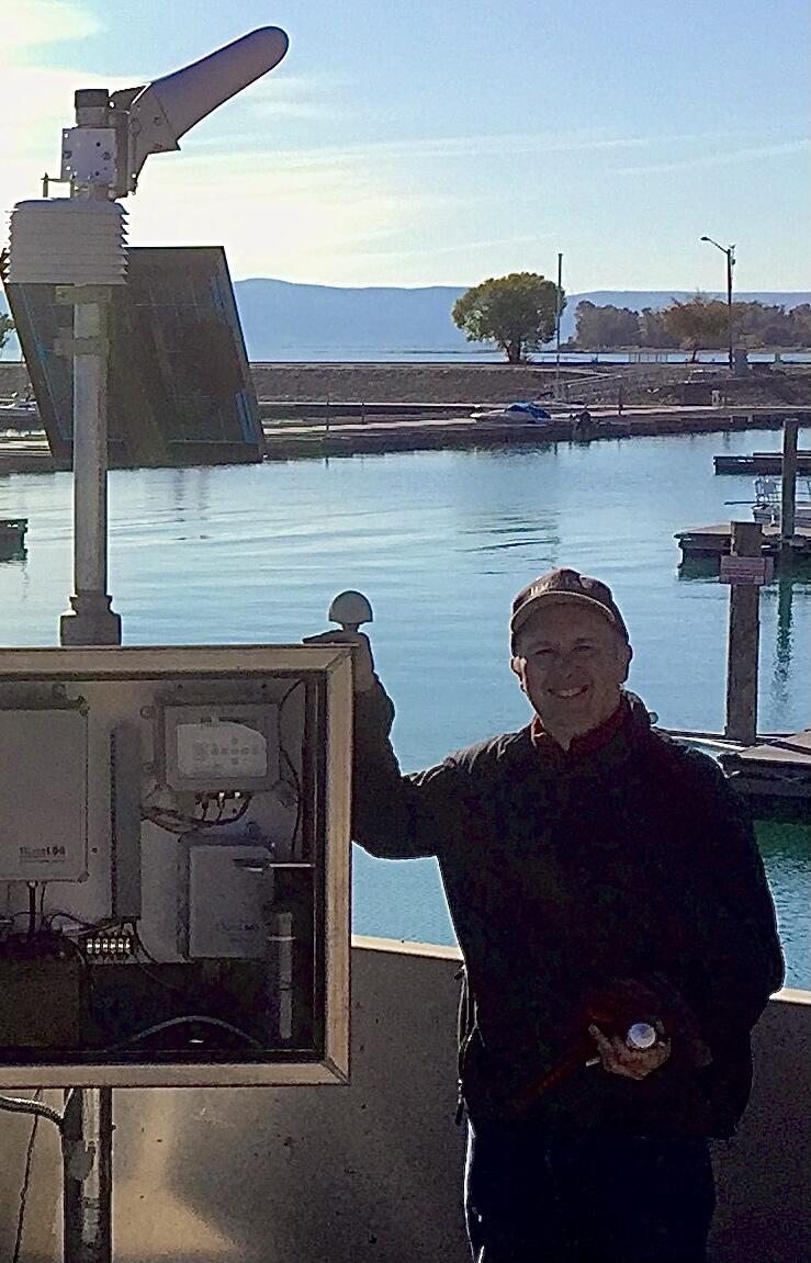 Hydrologic technician stands next to newly installed gage on Bear Lake in northern Utah