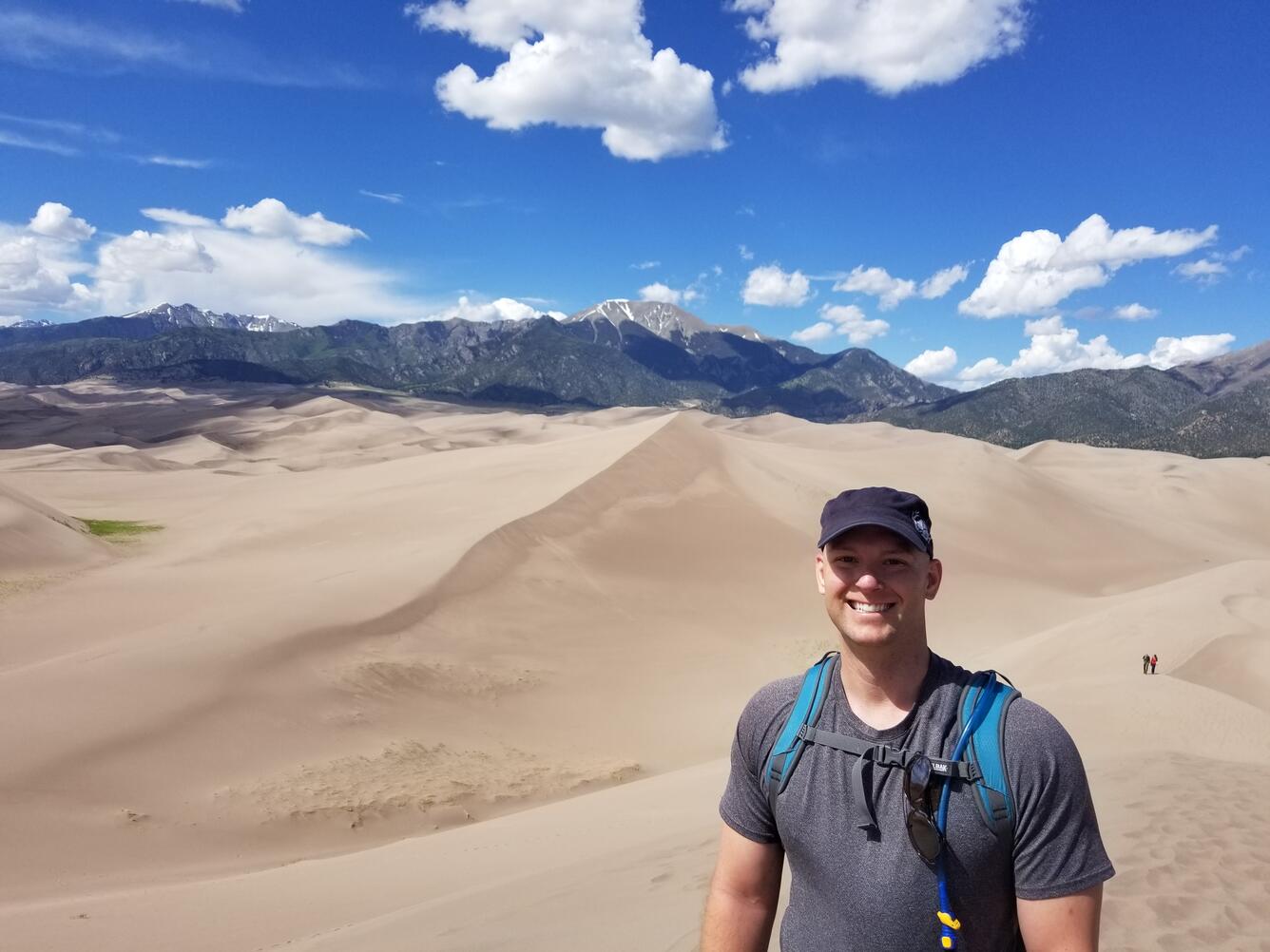 Image of Ryan Dunn with sand dunes and mountains in the background