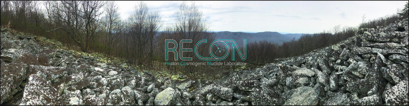 RECON Lab carousel image. Weathered rocks lay in the foreground. Tree covered mountains can be seen in the distance.