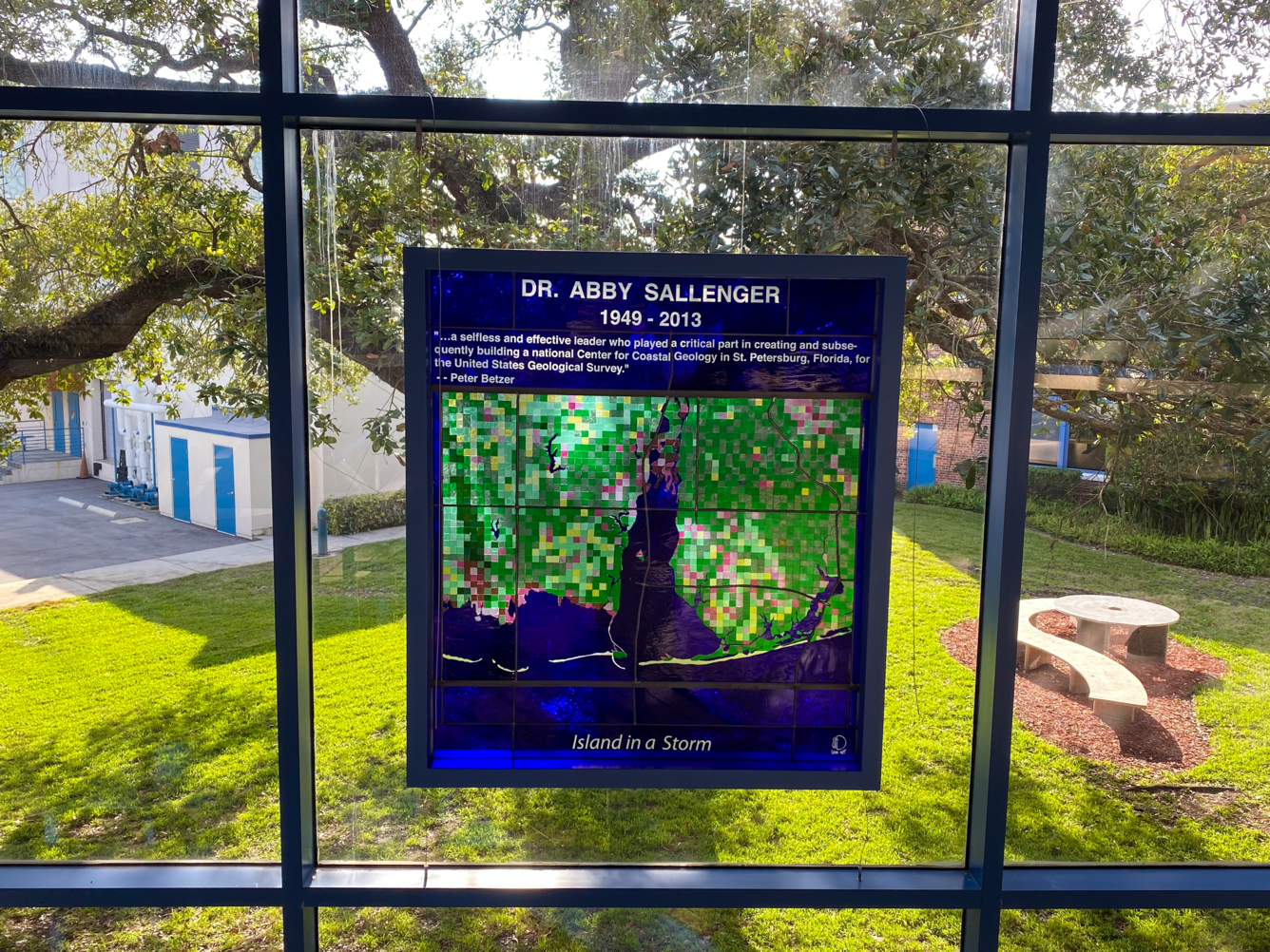 Stained glass art in window of coastal AL says, "Dr. Abby Sallenger, 1949-2013, Island in a Storm"