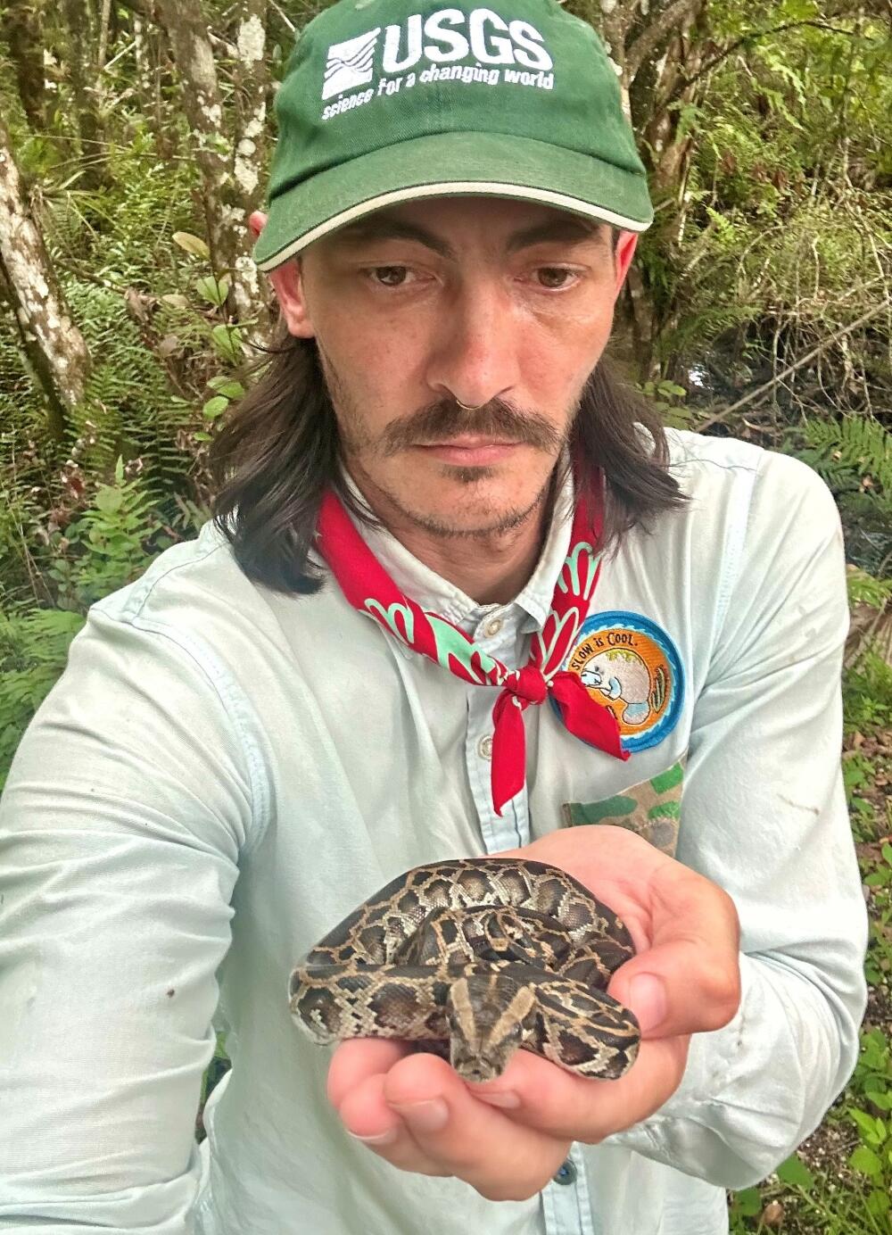 photo of a man holding a snake