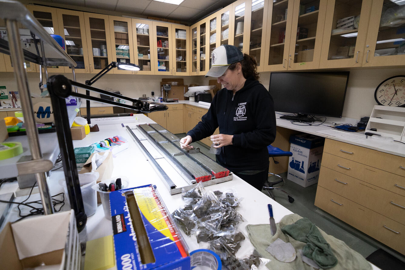 Scientists sub-sampling split sediment cores