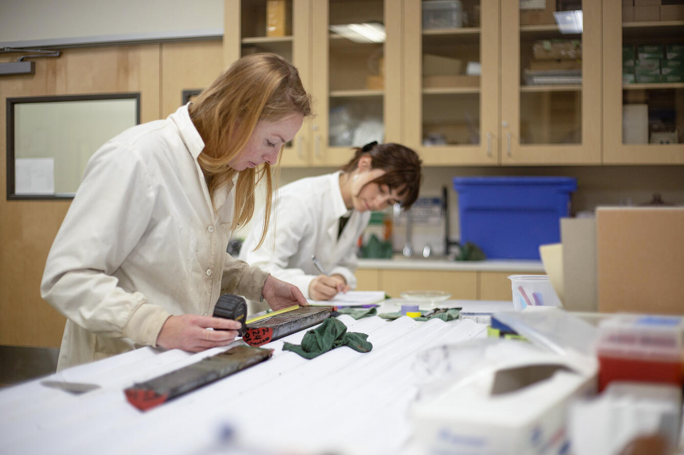 Scientists sub-sampling split sediment cores