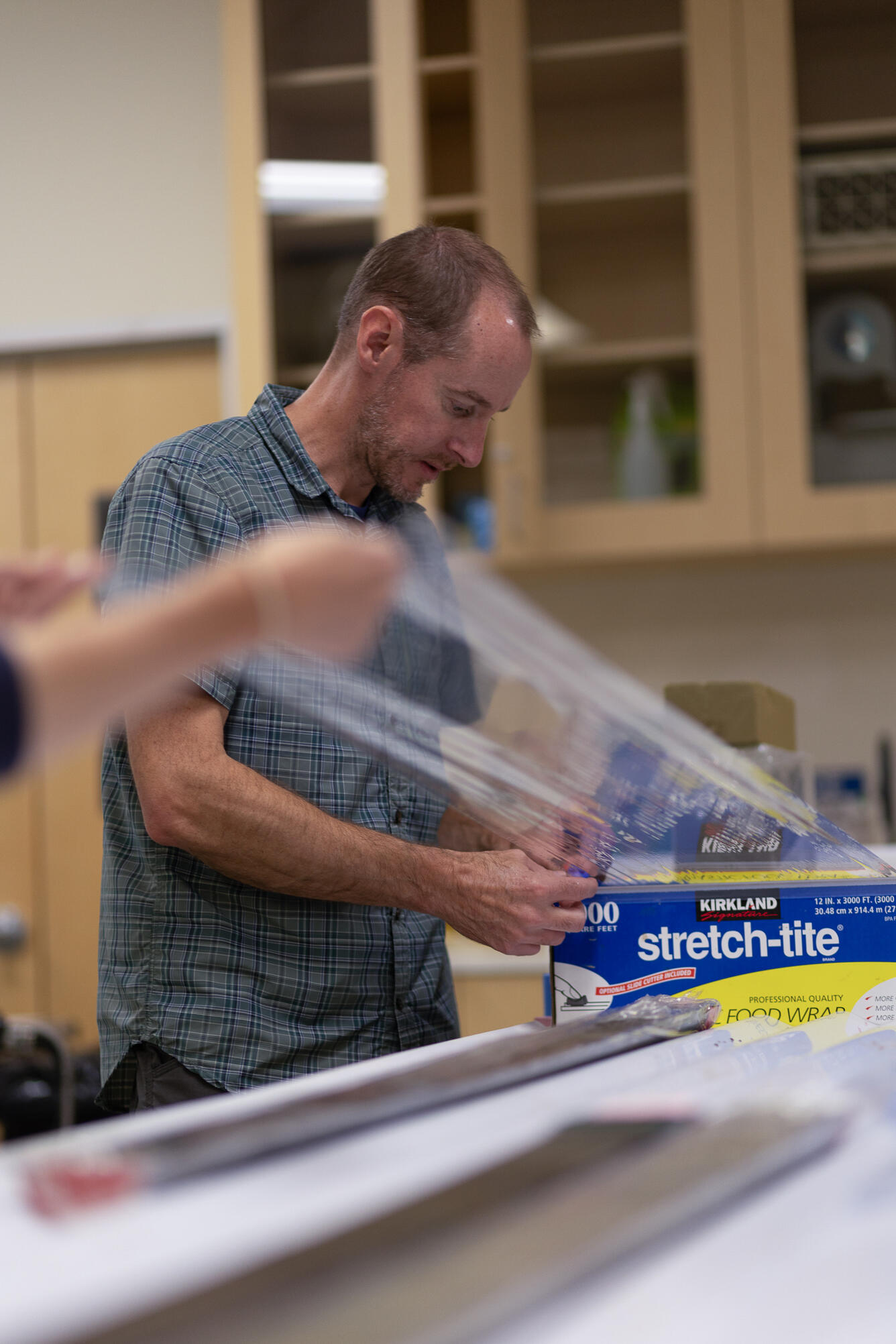 Scientists wrapping a split sediment core in plastic
