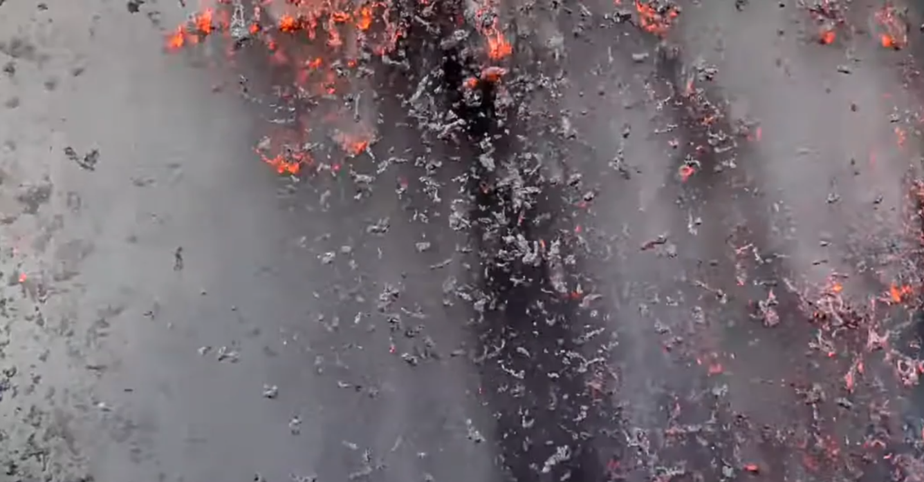 Color photograph of incandescent lava particles falling to the ground