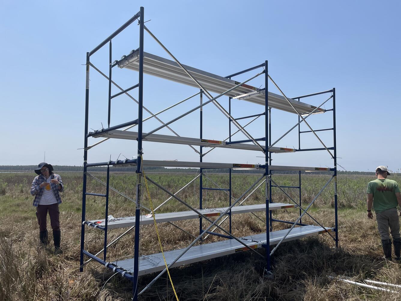 Two scientists walking around newly-assembled scaffolding