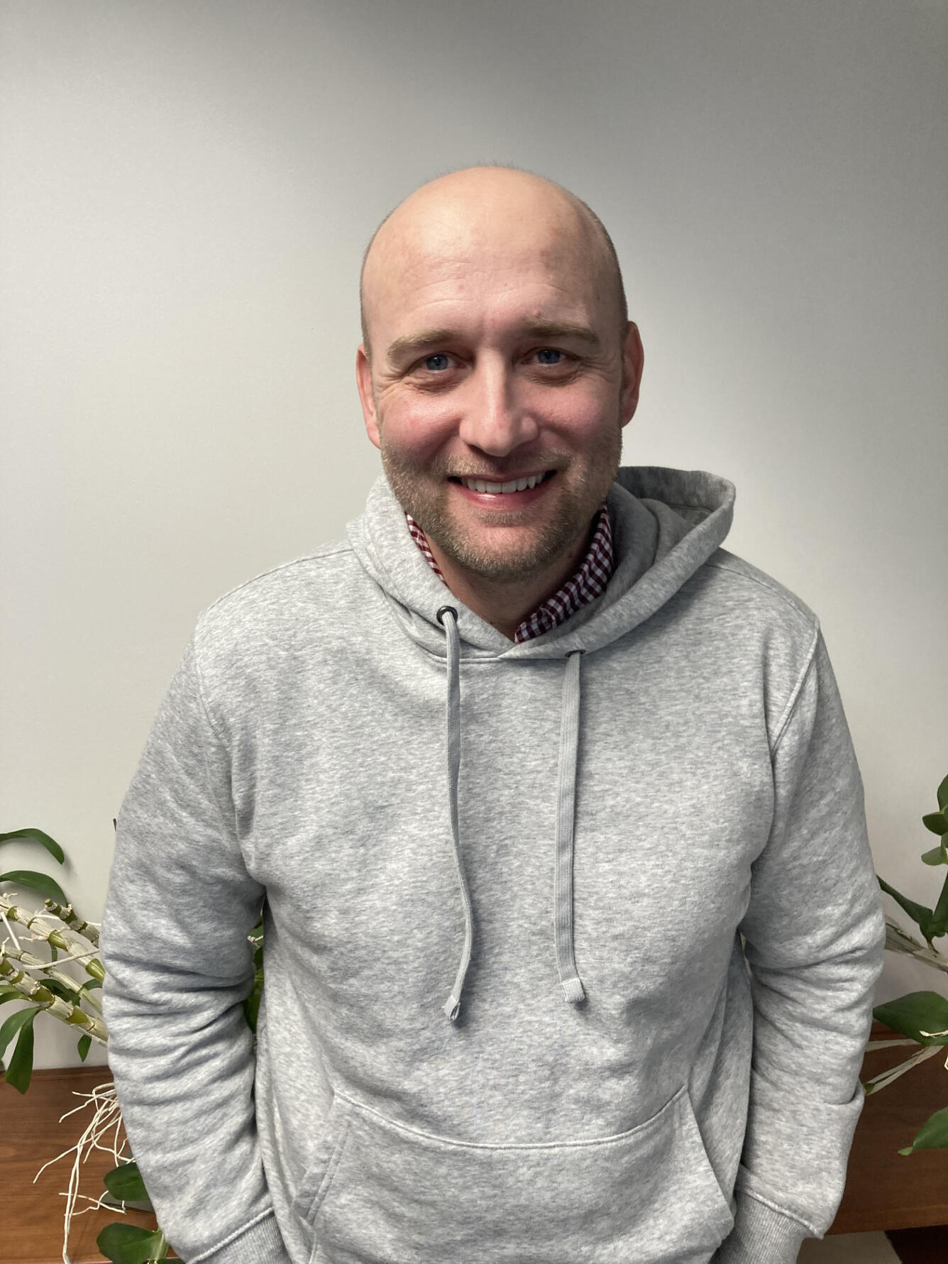 male scientist smiling, wearing a gray sweatshirt