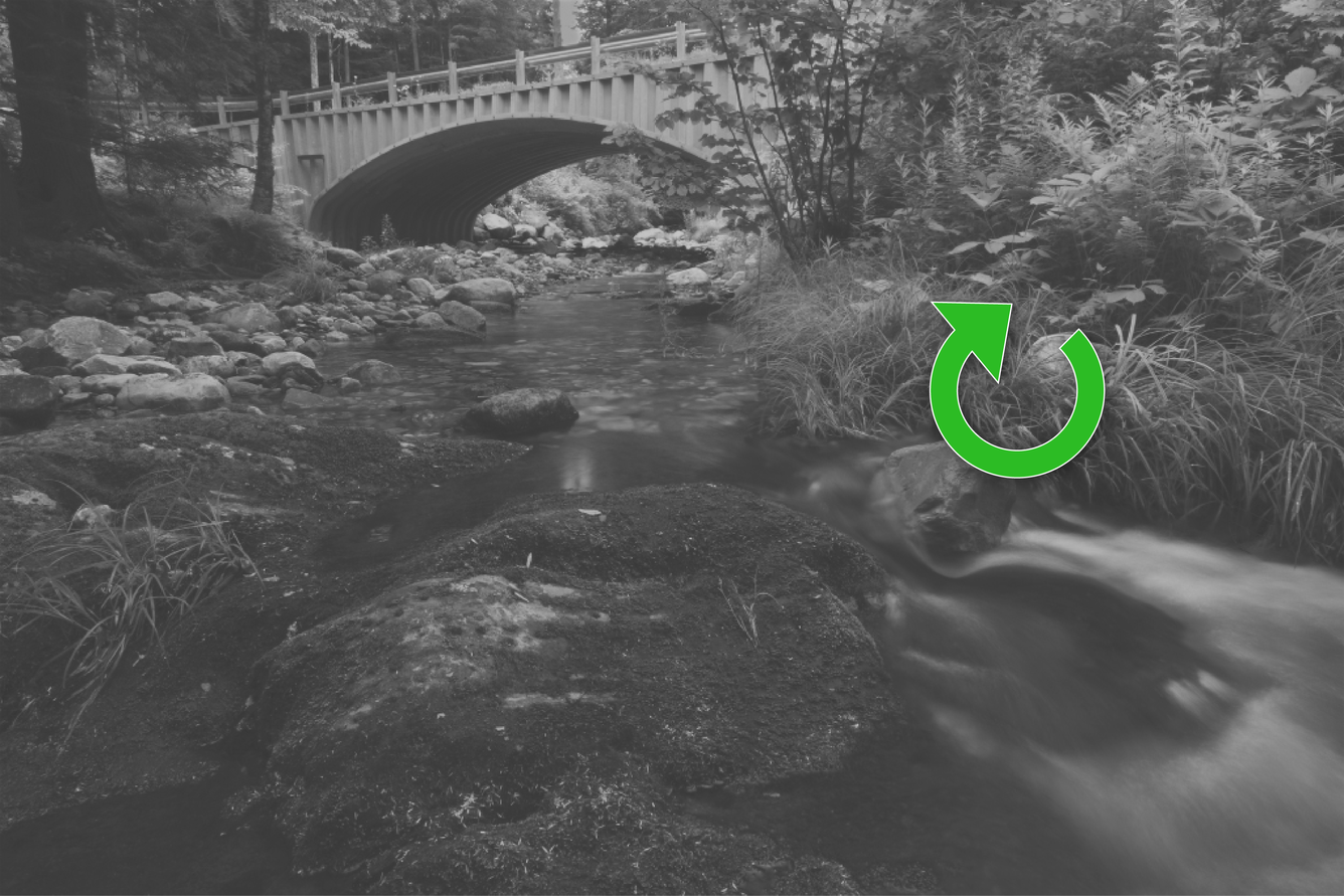 Faded black and white image of a stream with a bright green circular arrow