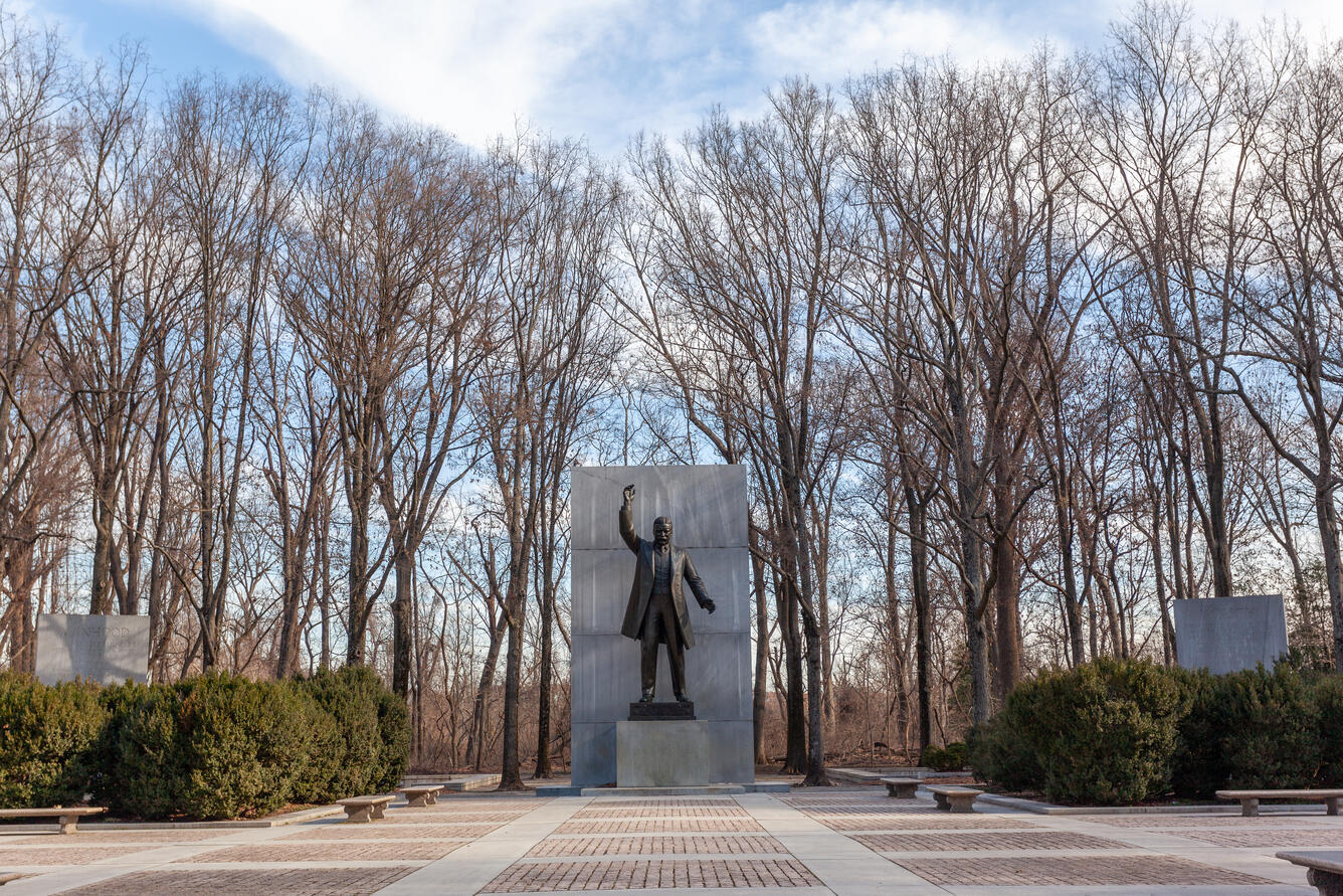 Theodore Roosevelt's statue has his right hand raised and he is standing as if he is speaking to a crowd.