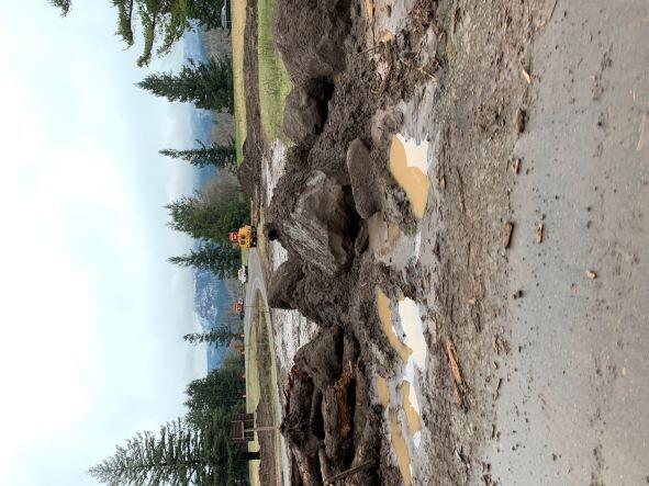 boulders and mud on ground next to roadway
