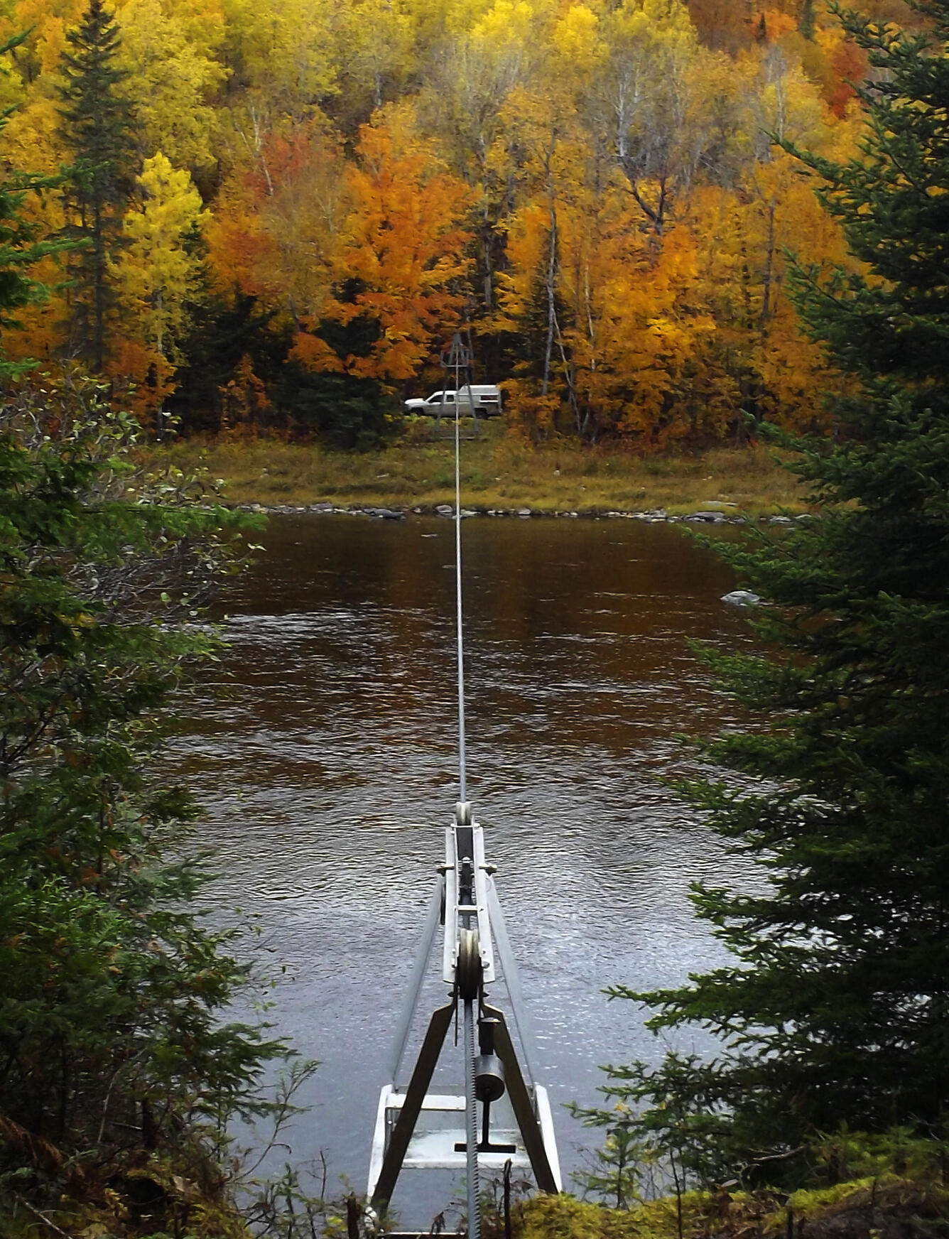 Survey equipment next to a river in the fall.