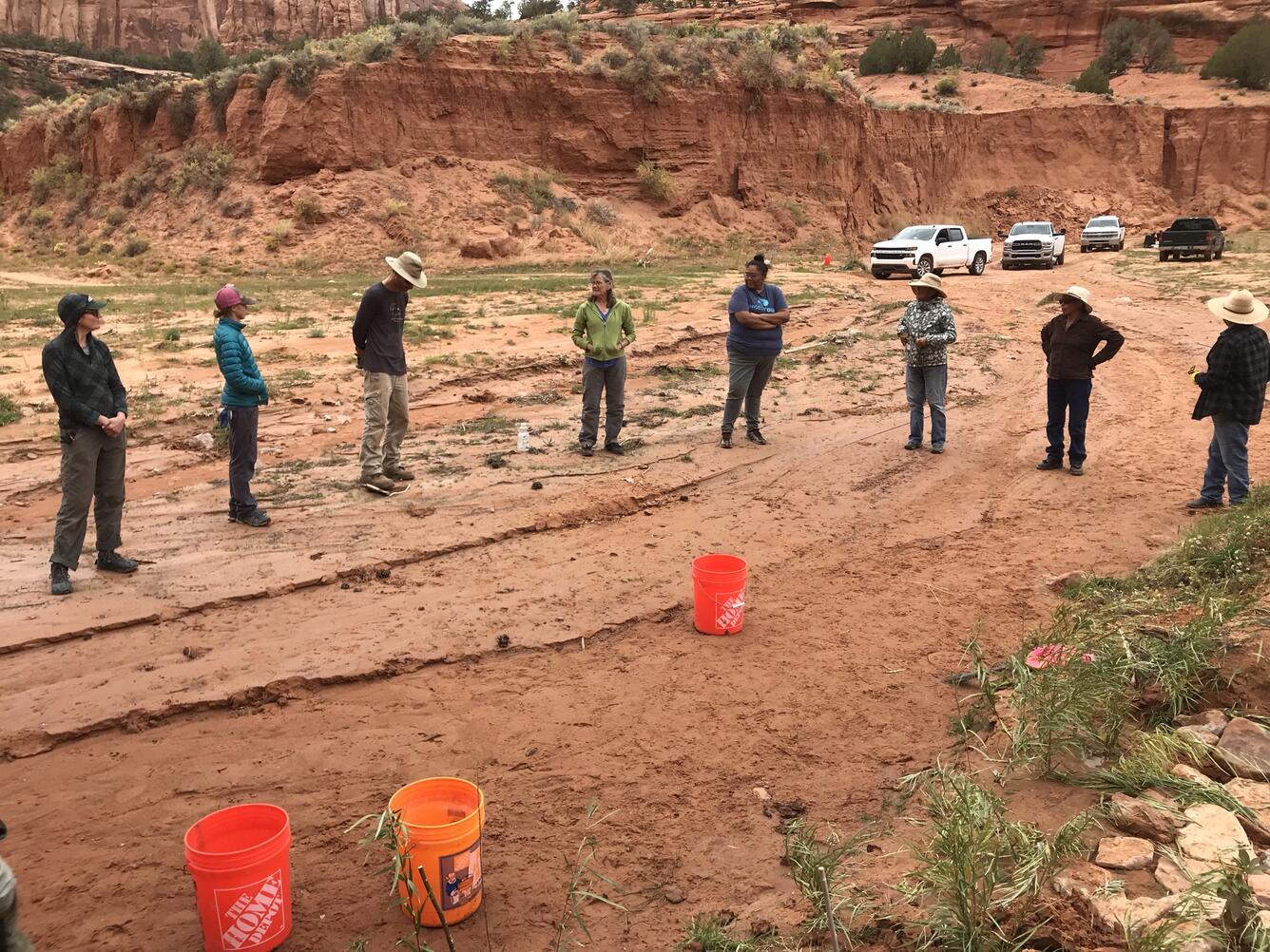 Group standing in a drywash surrounded by sandstone cliffs